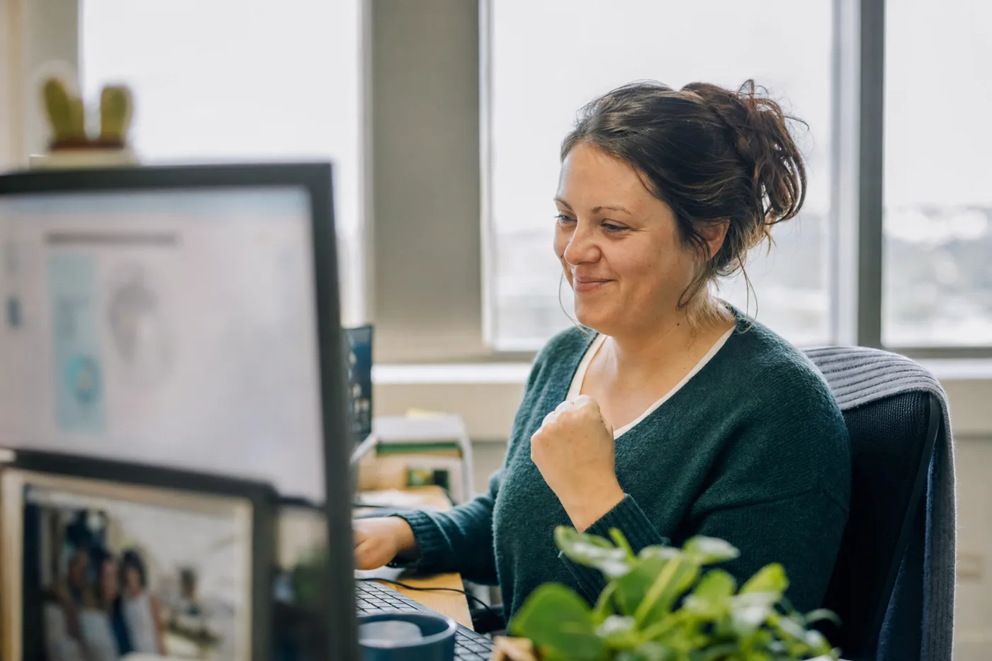 An employee smiling as an interactive AI tutor confirms her answer with instant feedback at her desk